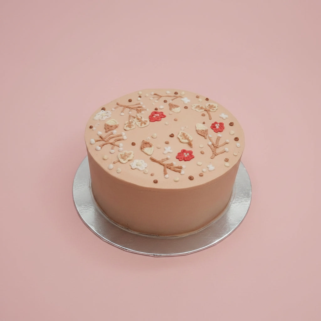 Small round cake with decorative elements on a marble surface