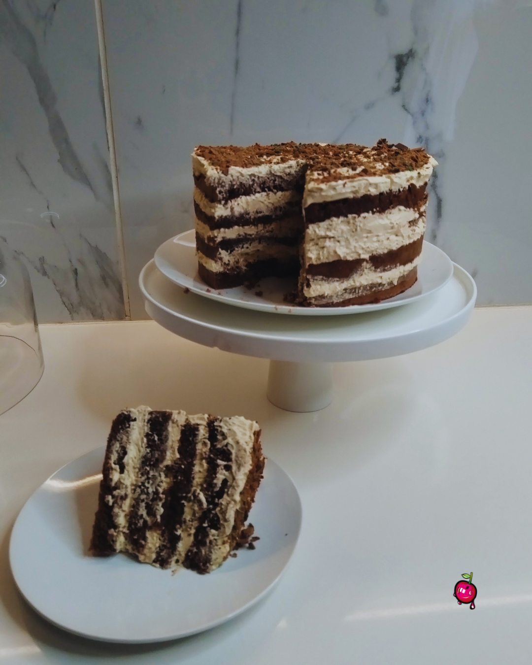 Layered cake on a white stand with a marble wall background