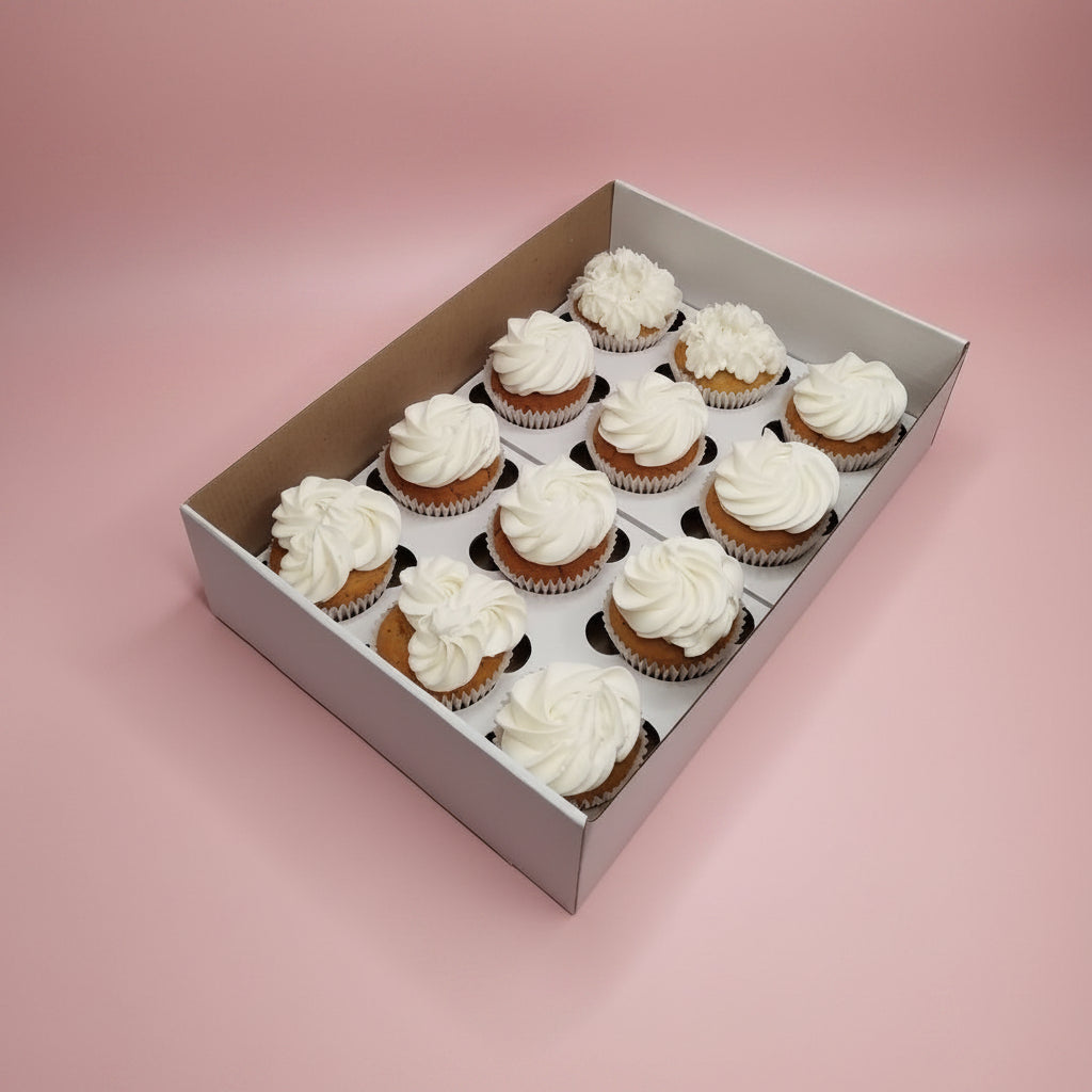 Box of cupcakes with white frosting on a marble surface